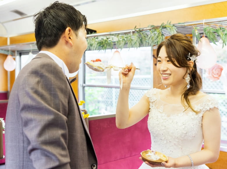 新婦が新郎にケーキを食べさせている写真