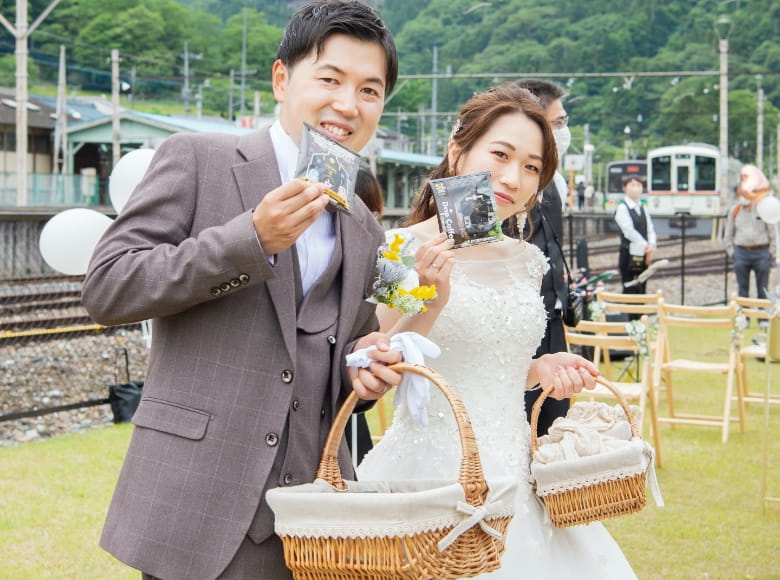 SLグッズを持ち笑う新郎新婦の写真