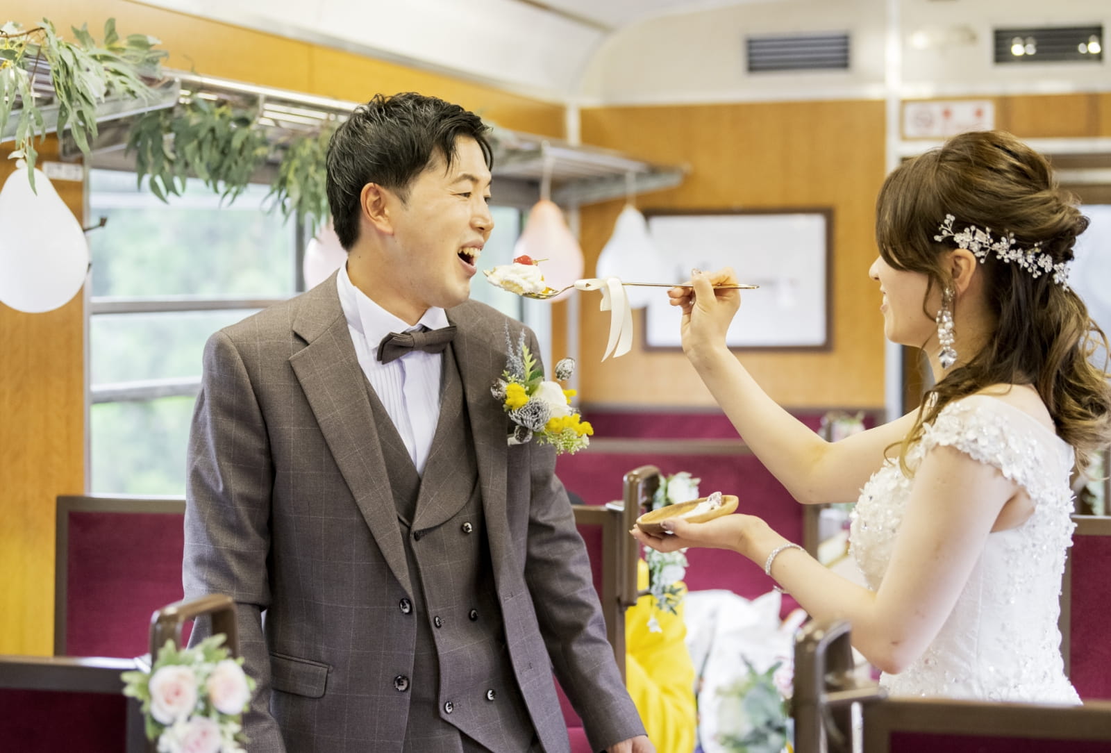 新婦が新郎にケーキを食べさせている写真