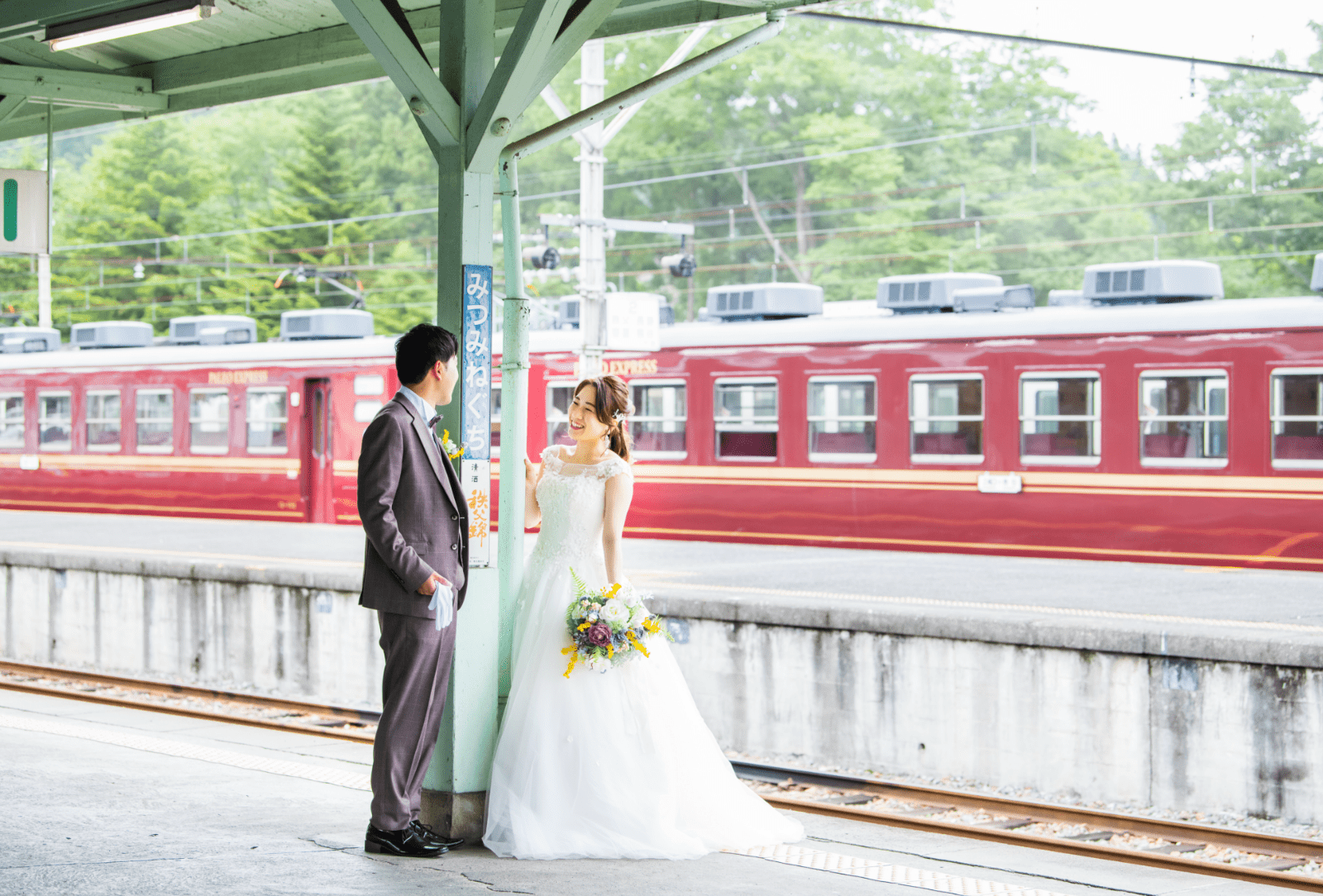 駅のホームで見つめ合う新郎新婦の写真